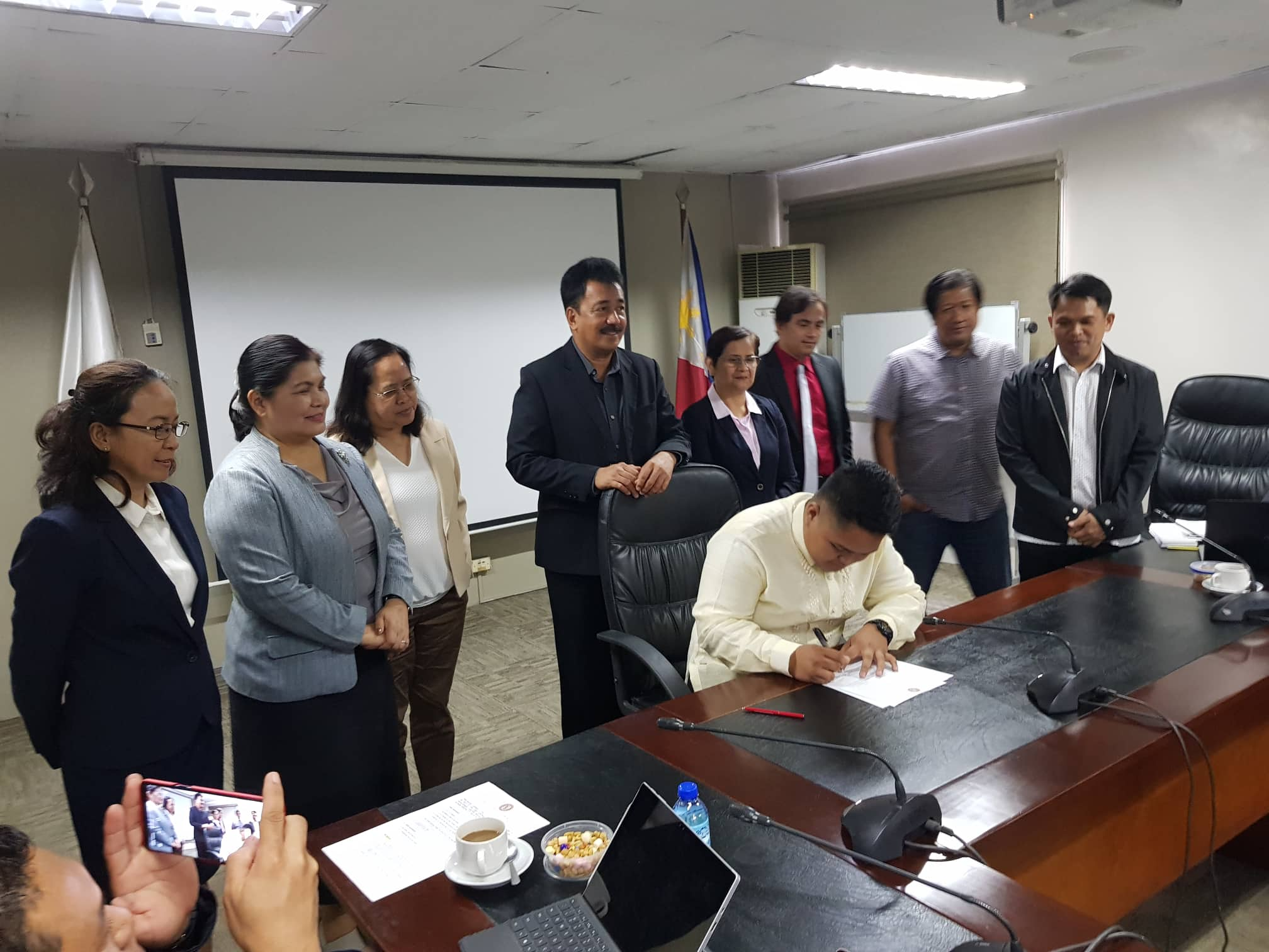 CHEd Chair, Dr. J. Prospero E. De Vera III, administers the oath of office of Keith William Casido Tanguileg, the new Student Regent of the Governing Board of the University.